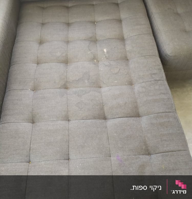 ספה אפורה עם כתמים ולכלוך על המושב